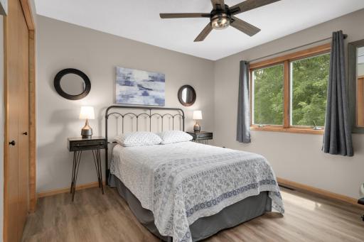 Another spacious Bedroom with updated flooring and views of the mature backyard trees.