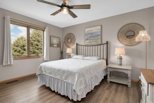 Comfortable secondary Bedroom with updated flooring and large window providing natural light.