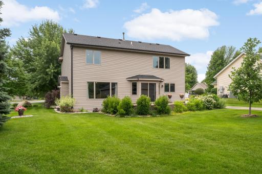 Enjoy the beautifully landscaped backyard featuring mature trees, lush lawn, and a spacious paver patio.