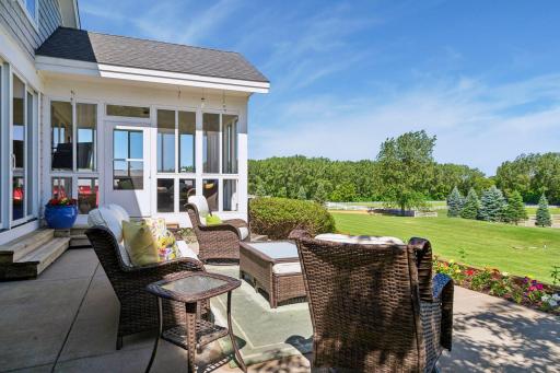 Lovely patio bordered by flowers, the perfect seat from which to watch neighboring horses graze or practice in the rink