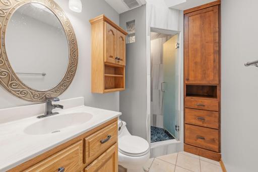 Primary ensuite back with walk-in shower & built-in linen storage.