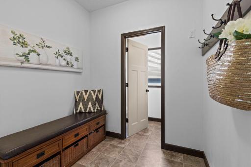 Functional mudroom with built in storage bench, coat hooks, and direct access to the oversized 3 car garage.