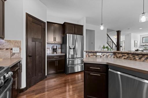 Well appointed kitchen with stainless steel appliances, corner pantry, breakfast bar seating, and abundant storage throughout.