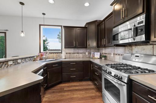 Thoughtfully designed kitchen with extensive countertop space, rich cabinetry, gas range, and excellent functionality for cooking and entertaining.