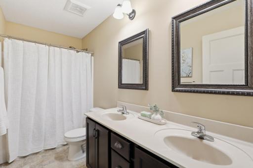 Upper level full bath with double sink vanity, abundant storage, and convenient access to the secondary bedrooms.