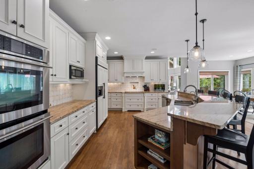 This gourmet kitchen with tile backsplash offers tons of counter space, storage and expansive center island to maximize the functionality.