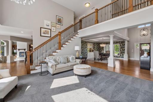View from the living room corner towards your grand front entry that offers space as all seem to gather here for long MN goodbyes. View towards kitchen and hearth room along with upper-level showcasing 2nd staircase.