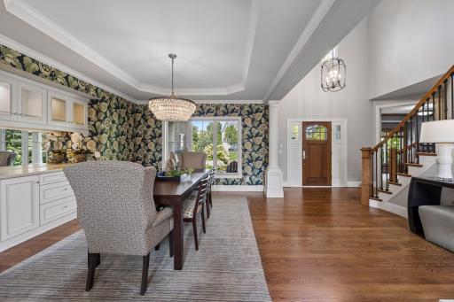 View towards your two-story entryway, covered front porch, inviting formal dining space and main level office is to the right with glass French doors.