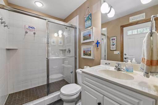 Tiled half bath with tile surround shower located off the billiard room with access to the pool decking which is IDEAL for all! Not in photo but also in the bathroom is the 2nd Laundry HERE for ease of washing all the pool towels.