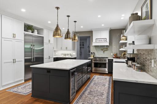 Expansive center island with Cambria countertops provides abundant prep space and full tile-to-ceiling back splash.