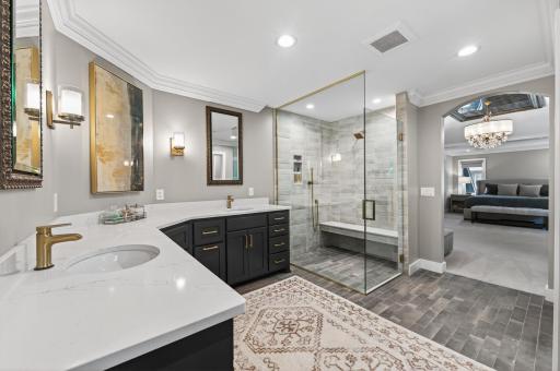 Luxurious, spa-caliber bath showcasing a frameless glass shower, upscale tilework, and toe-kick LED lighting.