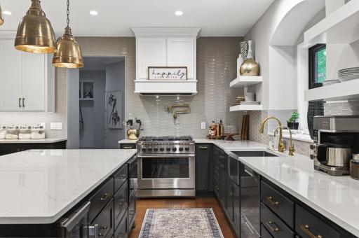 Fully remodeled chefâs kitchen featuring custom cabinetry, premium Fisher & Paykel appliances, Cambria quartz countertops, custom hood, pot filler, beverage refrigerator, and striking brass fixtures.