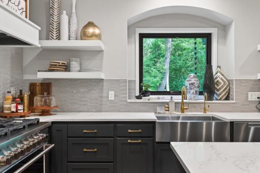 Oversized black modern window, and arched credenza inset, flood the space with natural light.