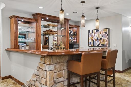 Inviting lounge retreat with a warm, âspeakeasyâ ambiance, featuring rich textures, custom millwork, and tailored lighting. Designed for comfort and conversation, this space flows effortlessly into the homeâs full entertainment level.