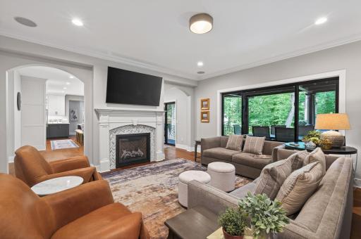 Living Room: Upgraded with bespoke cabinet work, a brand-new fireplace, new lighting, expansive modern black window and dedicated electrical/sound system updates.