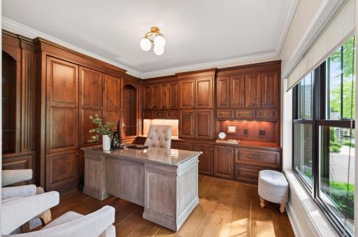 Main level executive office features custom built-in cabinetry featuring custom paint, hidden pull down Murphy Bed and premium, window treatments.