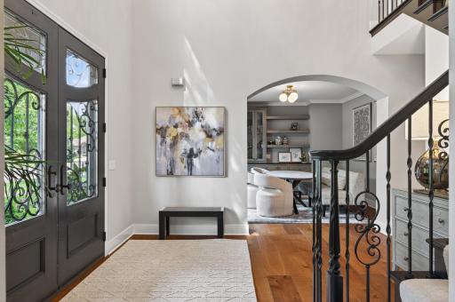 Showcasing exquisite craftsmanship, the custom front entry door and statement iron staircase establish a sense of luxury and architectural elegance that carries throughout the home.