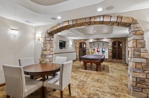 Sophisticated game room anchored by a classic billiards table (included), framed by dramatic stone archways and elevated finishesâperfect for recreation and entertaining alike.