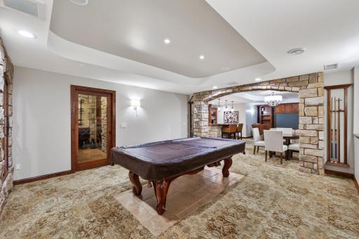 Architectural stone archways and custom millwork create a true âspeakeasyâ feel, complemented by designer lighting and premium wool carpeting for a rich, layered aesthetic.
