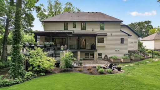 Private backyard retreat complete with manicured grounds, raised garden beds, a charming secret garden entrance, & multiple spaces designed for relaxation & entertaining.