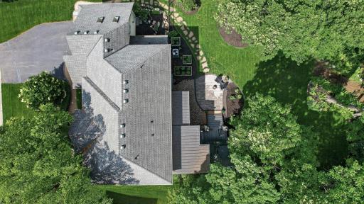 Aerial view highlighting the homeâs impressive footprint, thoughtfully designed outdoor spaces, and picturesque .4 acre wooded surroundings.