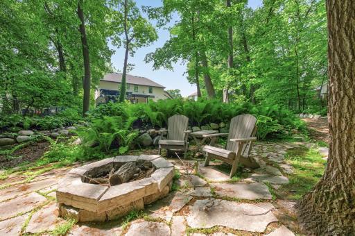 Secluded fire pit enclave nestled within natural surroundings, providing a peaceful escape and an intimate extension of the homeâs exceptional outdoor living.