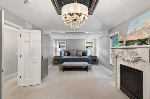 Tranquil and spacious primary suite retreat featuring a fireplace, soft neutral palette, and refined architectural detailing.