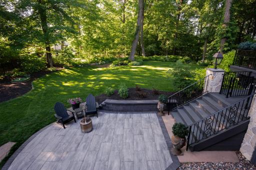 Shaded backyard with mature tree coverage, level lawn, and patio areaâproviding natural shade, privacy, and functional outdoor living space.