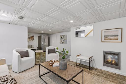 Bright and inviting family room showcasing generous seating space, custom coffered ceiling detail, neutral finishes, recessed lighting, and multiple storage closets for added functionality.