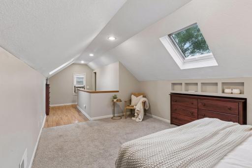 A cozy seating nook creates the perfect place to unwind with your favorite book, while the skylight fills the room with soft natural light.