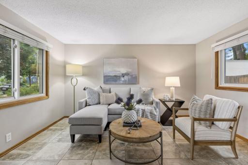 Large windows fill the living room with abundant natural light, creating a bright and welcoming atmosphere throughout the day.