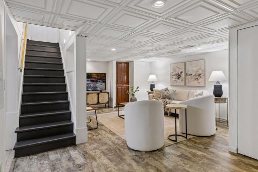 The finished lower-level family room offers stylish flooring and a warm, inviting atmosphere perfect for everyday living.