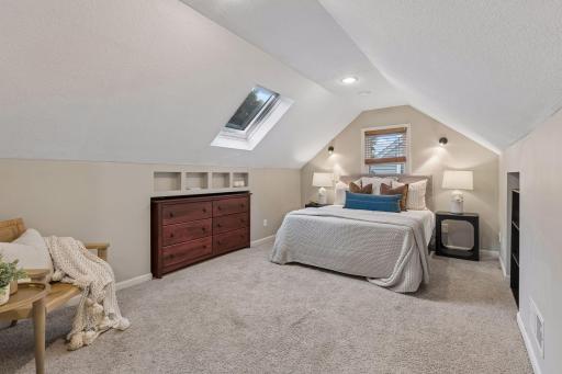Retreat to the spacious upper-level primary bedroom featuring impressive ceiling height that creates an open, airy feel.
