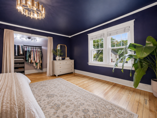 Virtually Staged Primary Bedroom with beautiful hardwood floors, crown molding and custom closet system