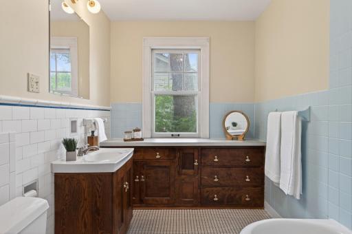 Full bathroom featuring vintage character and built-in storage.