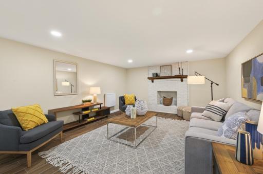 Finished lower-level family room with decorative fireplace.