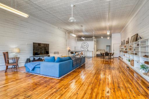 Expansive great room with restored hardwood floors and original punched tin ceiling