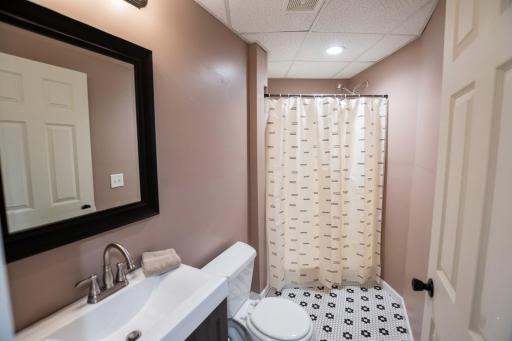 Lower level 3/4 bathroom with tile floor.