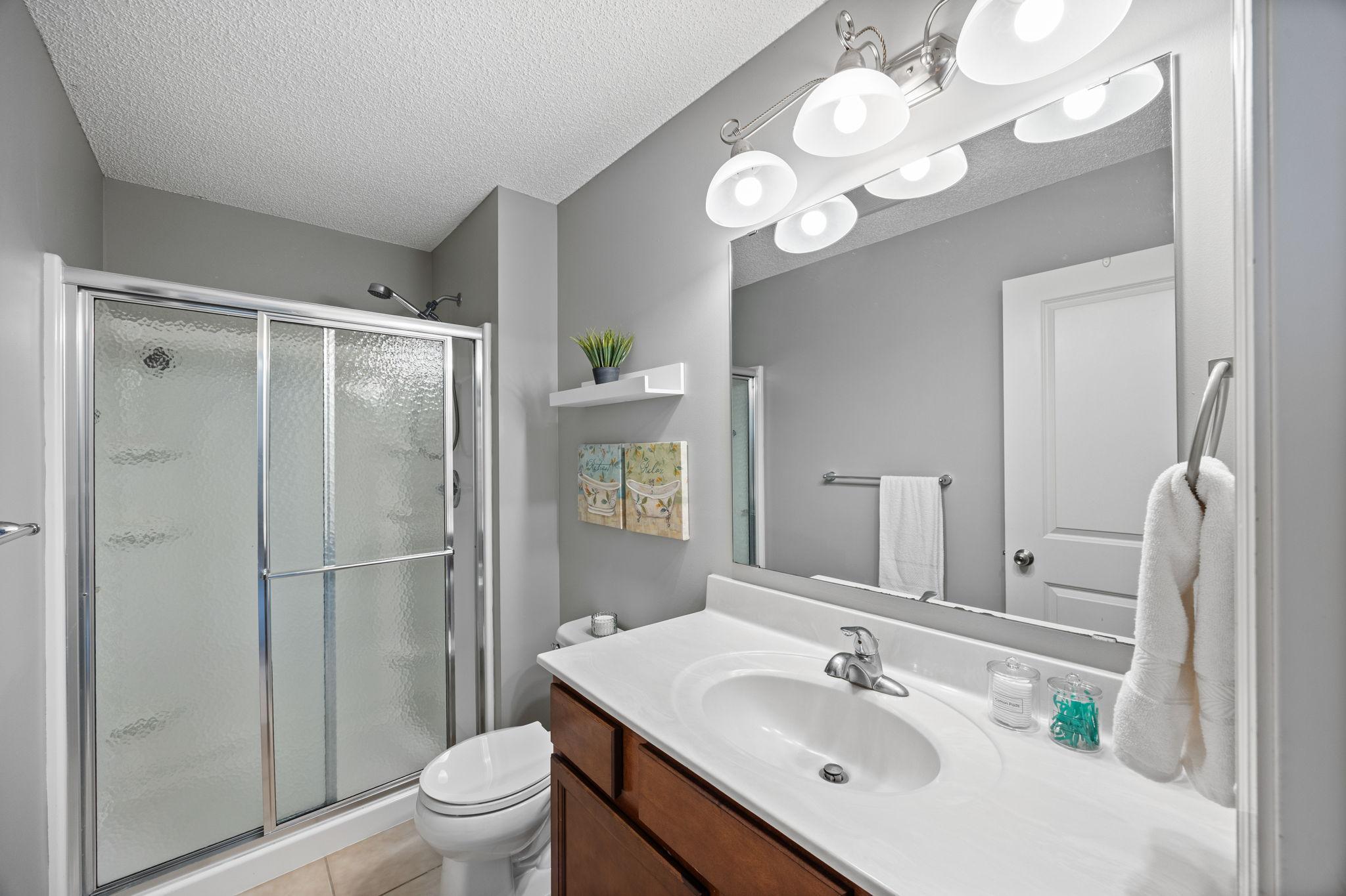 Private bathroom complete with tile flooring, vanity, and walk-in shower!
