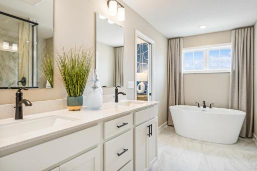 (Photo of model home, finishes will vary) Featuring a sophisticated dual-sink vanity with separate mirrors, this en-suite bathroom ensures streamlined morning routines