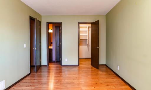 Primary bedroom with large walk-in closet and built in shelving. It also has a walk-through to the main level full bath.