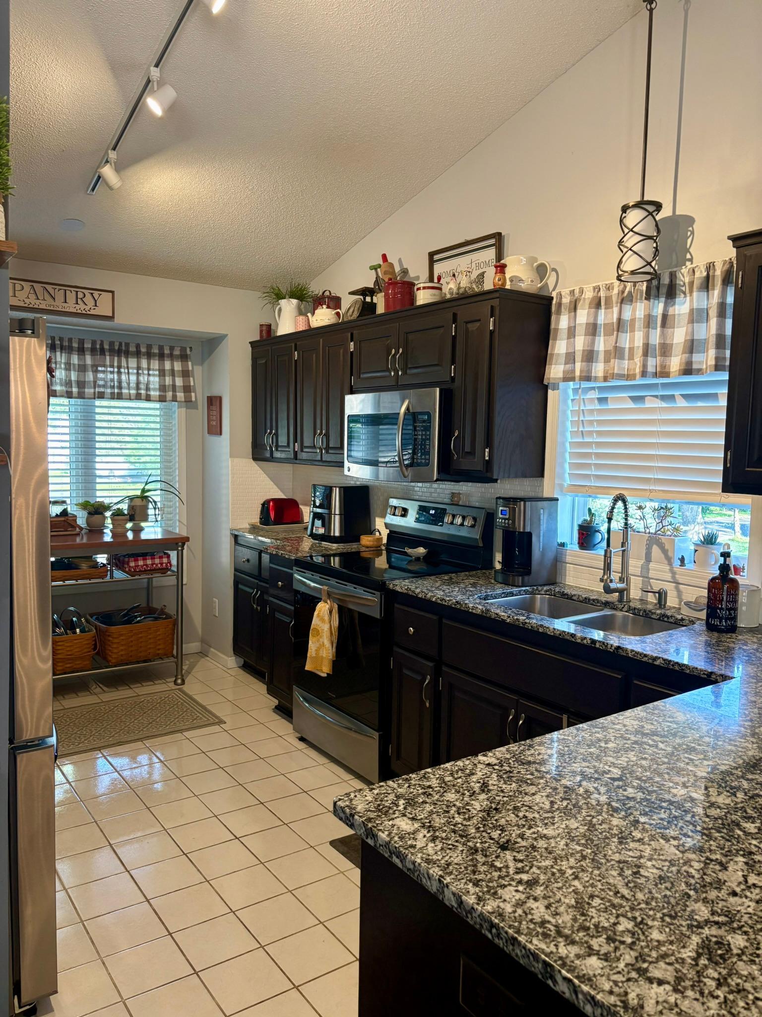 Kitchen with granite counters, tile backsplash and stainless appliances