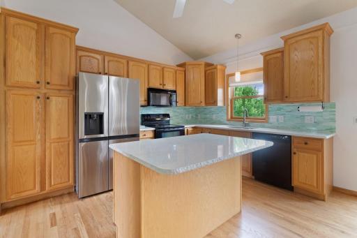 Kitchen with raised panel cabinetry and vaulted ceilings