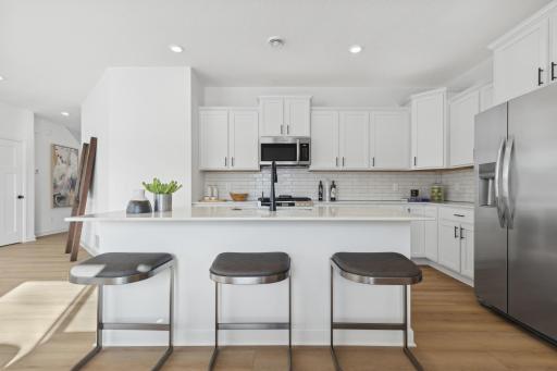 (Photo of a decorated model, actual homes finishes will vary) Enjoy plenty of seating at the kitchen island and dining area adjacent to the kitchen.