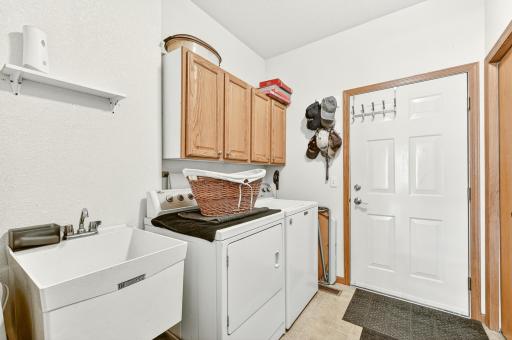 Laundry room off kitchen and garage with storage