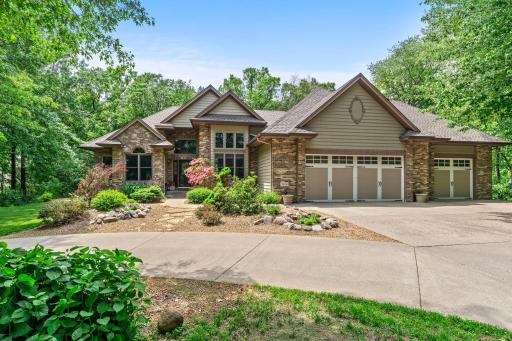 A quiet approach home, surrounded by mature trees and a welcoming circular driveway.