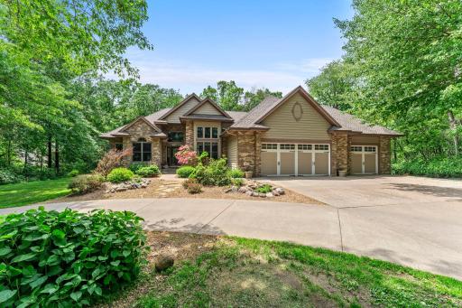A quiet approach home, surrounded by mature trees and a welcoming circular driveway.