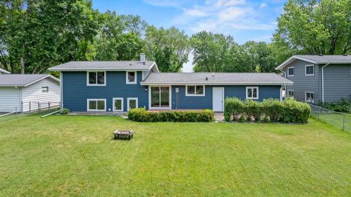 The backyard features a deck, patio, shed, and chain-link fence.