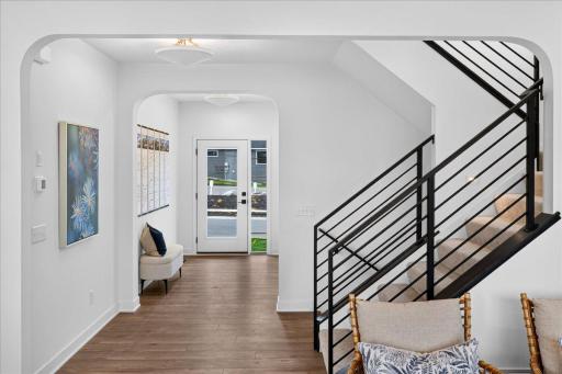 Soft arches and metal railings add an elevated feel upon entering the home