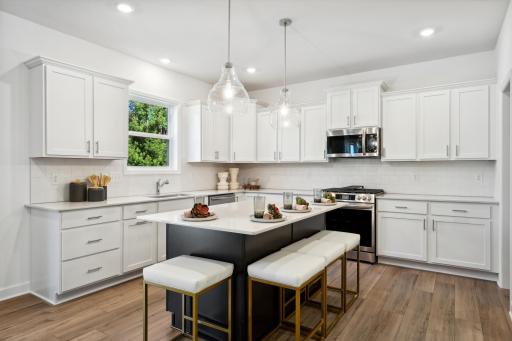 This stylish kitchen showcases a large center island, Shaker-style cabinetry, and brand-new stainless-steel appliances.